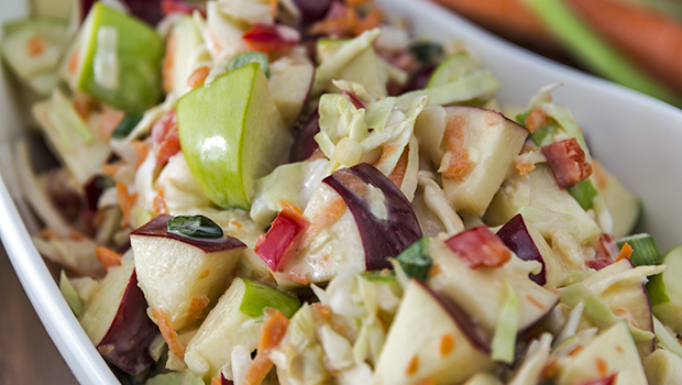 Diced green and red apples with cabbage and sliced carrots with mayonnaise-based dressing