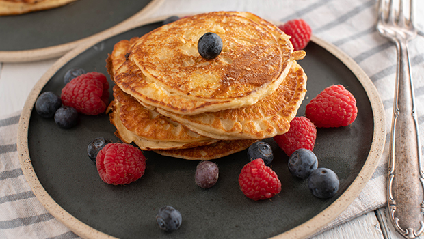 Stack of pancakes with raspberries and blueberries on a plate