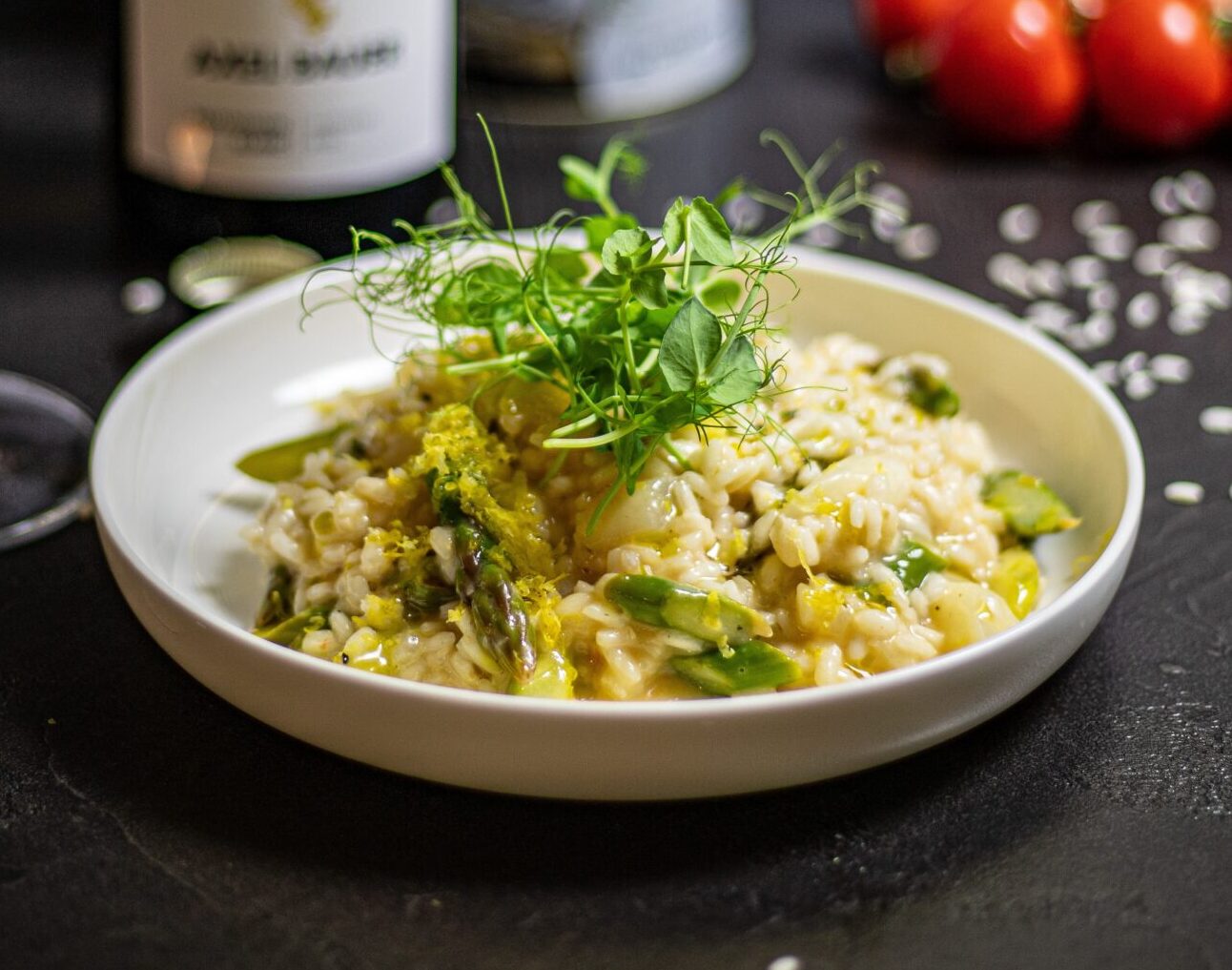Risotto with asparagus and a garnish in a shallow white bowl