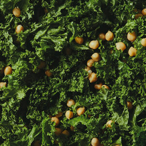 Top-down view of a large blue bowl with kale and chickpeas