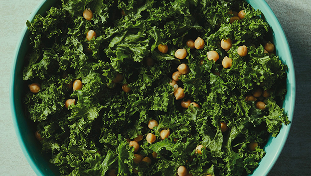 Top-down view of a large blue bowl with kale and chickpeas